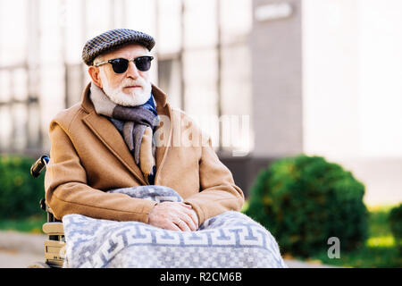 Bel homme dans la haute mobilité Fauteuil roulant avec plaid sur les jambes on street Banque D'Images