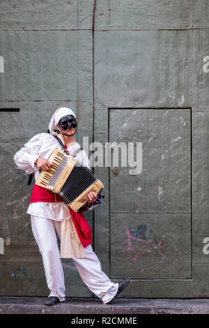 Artiste de rue wearing mask, jouant de l'accordéon. Photographié à Naples, en Italie. Banque D'Images