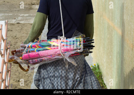 Forte dei Marmi , Italie .. novembre 01, 2018 : Groupe des parasols colorés vendus par les immigrants africains Banque D'Images