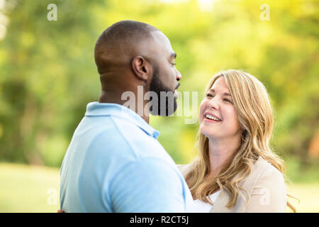 Aimer mixed race couple hugging and laughing. Banque D'Images