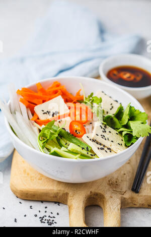 Nouilles de riz vietnamiens avec le tofu et légumes à salade chili bol blanc, vue du dessus. Banque D'Images