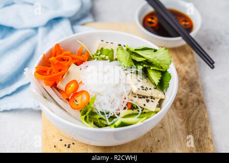 Nouilles de riz vietnamiens avec le tofu et légumes à salade chili bol blanc, vue du dessus. Banque D'Images