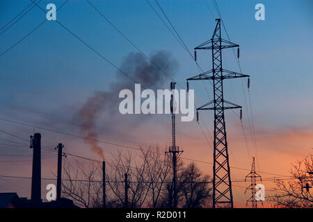 Attributs de l'urbanisation et de la pollution de l'environnement. Les lignes électriques et les tuyaux de fumée d'usine avec de l'air polluants. Conséquences de l'activité humaine Banque D'Images