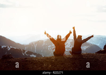 Deux heureux randonneurs se trouve en montagne avec les bras levés et s'amuser Banque D'Images