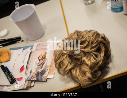 Mainz, Allemagne. 19 Oct, 2018. Il y a une perruque sur la table de composition de classe. Le traitement du cancer par chimiothérapie ou radiothérapie traitement peut changer radicalement l'apparence de la peau avec la perte de cheveux, perte de cils et sourcils ou des irritations de la peau. Le fichier de donneurs de moelle osseuse, Allemand (DKMS) propose pour les femmes concernées en particulier sur il a coordonné les cours de mise à niveau. (Pour 'dpa avec make-up pinceau et la peinture contre les traces de cancer' à partir de 19.11.2018) Crédit : Andreas Arnold/dpa/Alamy Live News Banque D'Images