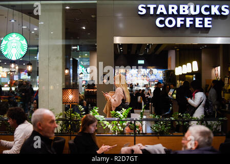 Les personnes sont considérées marche à côté de Starbucks Coffee shop. Banque D'Images