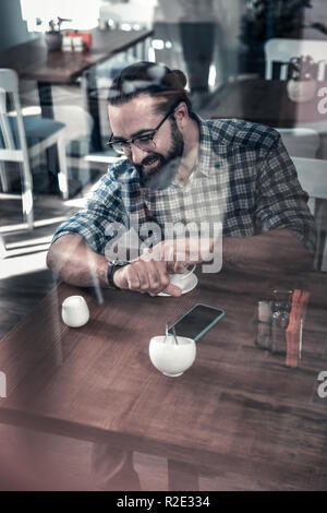 Homme barbu à la main à regarder en retard pour travailler Banque D'Images