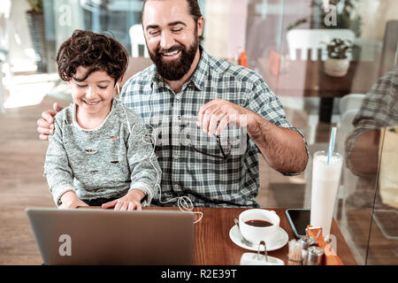 Cheerful transmission d'un père et son fils s'amusant sur week-end à cafétéria Banque D'Images
