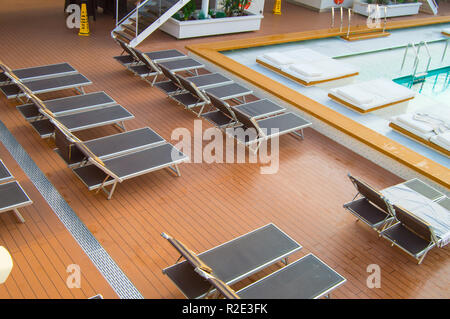 Vue de dessus de la luxueuse piscine avec transats vides sur le pont d'un paquebot de croisière moderne Banque D'Images
