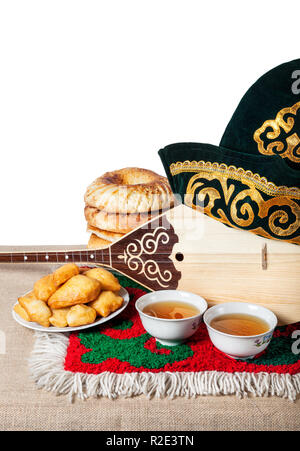 Des plats asiatiques, thé et Kazakh Dombra instrument sur la table avec des tapis orientaux Banque D'Images