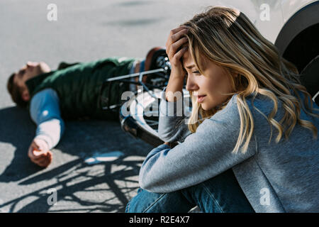 Femme peur de pleurer près de voiture après une collision avec le trafic cycliste Banque D'Images