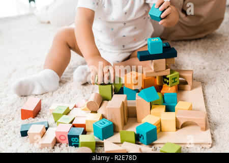 Portrait de l'adorable bambin jouant avec des cubes colorés Banque D'Images