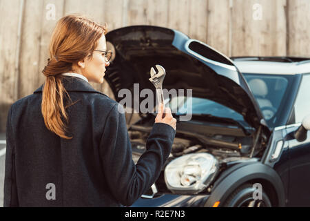 Portrait de femme en robe avec une clé debout près de voiture à city street Banque D'Images