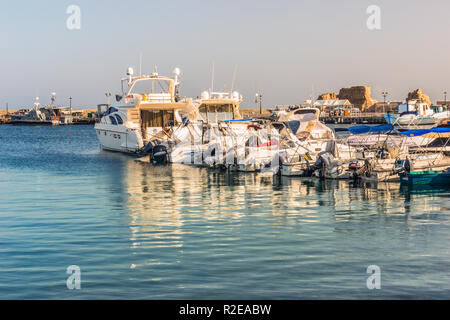 Paphos, Chypre - 20 septembre 2016 : Blanc yachts et bateaux sur le quai dans le port de Paphos, dans les rayons de soleil. Fragment de la ruine d'un ancie Banque D'Images