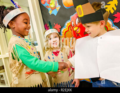 Une école qui s'élève est habillé en costume anIndian, serre la main avec un étudiant vêtu comme un pèlerin, le 21 novembre 2012, à Columbus, Mississippi. Banque D'Images