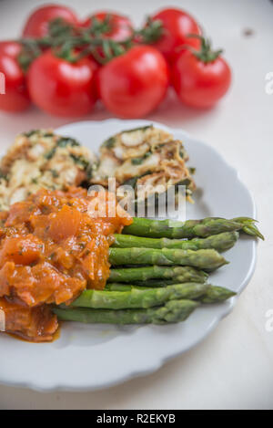 Asperges cuites à la sauce tomate Banque D'Images