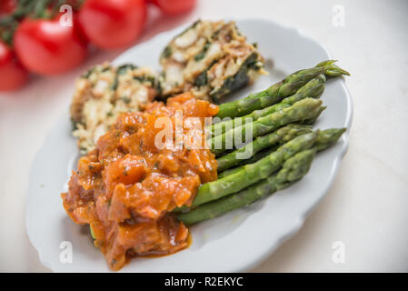 Asperges cuites à la sauce tomate Banque D'Images