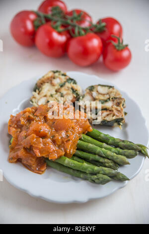 Asperges cuites à la sauce tomate Banque D'Images