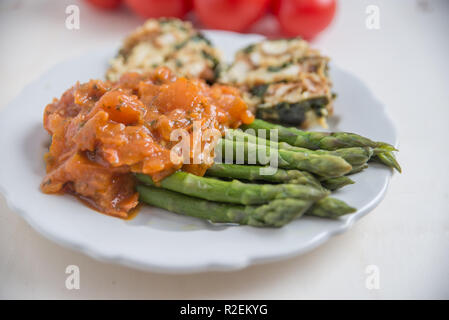 Asperges cuites à la sauce tomate Banque D'Images