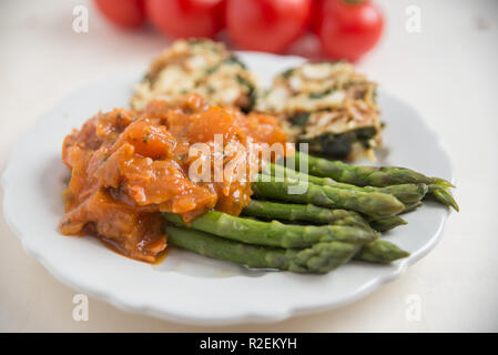 Asperges cuites à la sauce tomate Banque D'Images