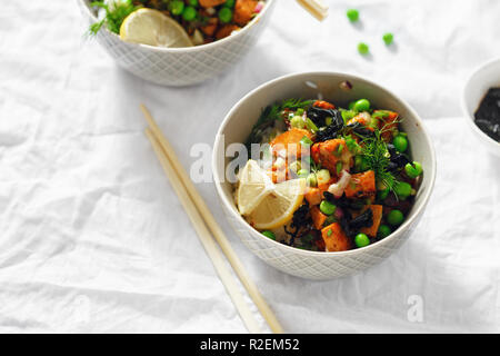 Deux bols poke végétarien. Le tofu, le riz, les algues, les pois verts et oignons savoureux et sain la nourriture végétarienne Banque D'Images