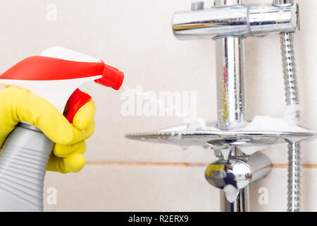 Personne portant des gants en caoutchouc de pulvérisation hygiénique porte-savon douche comme concept de tâches Banque D'Images
