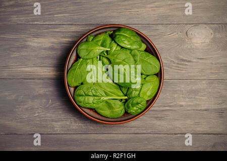 Les feuilles d'épinards vert brun en coupe sur table rustique . Les aliments biologiques.Vue de dessus.Le concept photo de poids perdu. Banque D'Images