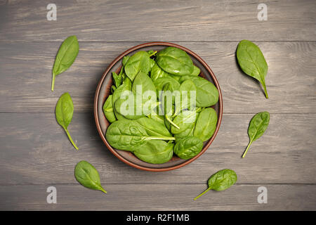 Les feuilles d'épinards verts en brun foncé sur le bol alimentaire feuillus comme arrière-plan un concept de saine alimentation frais jardin produisent des aliments biologiques comme un symbole de Banque D'Images