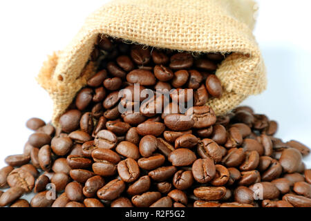 Tas de grains de café torréfiés dispersés à partir de sac de toile Banque D'Images
