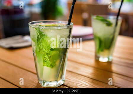 Deux verres de mojito cocktail avec de la chaux et de menthe sur table en bois Banque D'Images