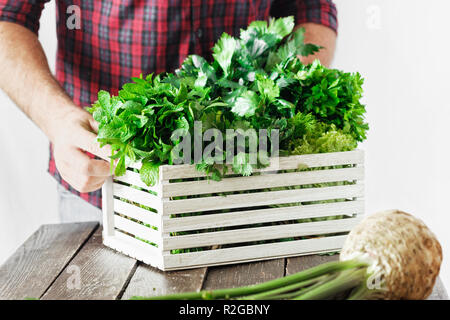 Agriculteur avec des herbes dans la boîte en bois sur la table en bois close up concept de récolte Banque D'Images