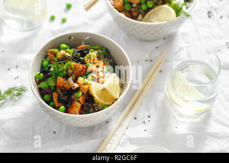 Deux bols poke végétarien. Le tofu, le riz, les algues, les pois verts et oignons savoureux et sain la nourriture végétarienne Banque D'Images