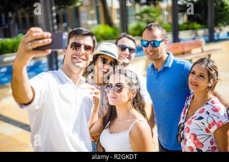 Groupe de six amis heureux de prendre au cours de la journée d'été ensoleillée selfies Banque D'Images