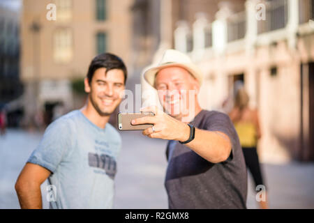 Deux amis en tenant dans les selfies smartphone ville Banque D'Images