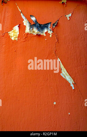 La peinture et le plâtre se détache d'un mur orange Banque D'Images