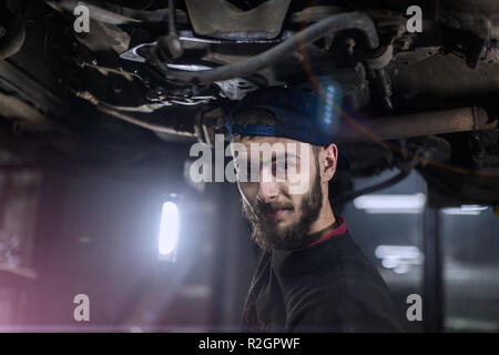 Young caucasian man la réparation de voiture avec des outils professionnels Banque D'Images