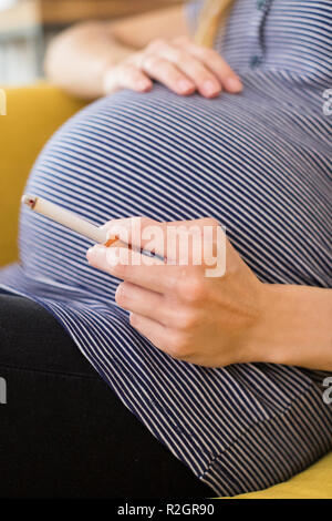 Close Up of pregnant woman smoking Cigarette Banque D'Images