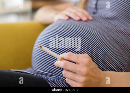 Close Up of pregnant woman smoking Cigarette Banque D'Images