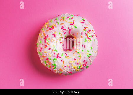 Rond donut unique sur fond rose. Banque D'Images