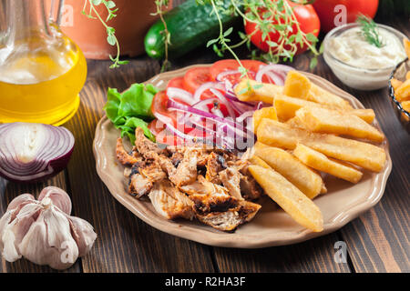 Les gyros grec lave avec frites et légumes. Servi avec sauce tzatziki Banque D'Images