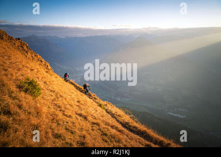 L'homme et la femme du vélo de montagne dans les Alpes autrichiennes au coucher du soleil près de Gastein, Salzbourg, Autriche Banque D'Images