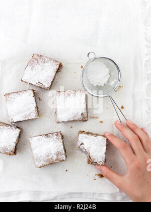 Woman's hand reaching pour un chocolat blanc blondies au caramel Banque D'Images