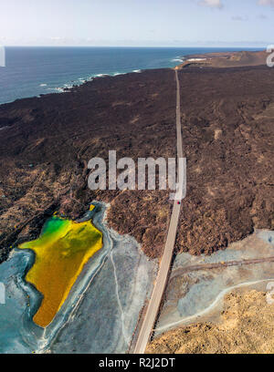 Vue aérienne du petit lac sous la montagne Bermeja, vue de la plage noire et la route côtière. Lanzarote, îles Canaries, Espagne Banque D'Images