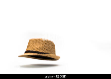 À la baisse d'un chapeau. Une paille chapeau panama tombant sur un fond blanc. Banque D'Images