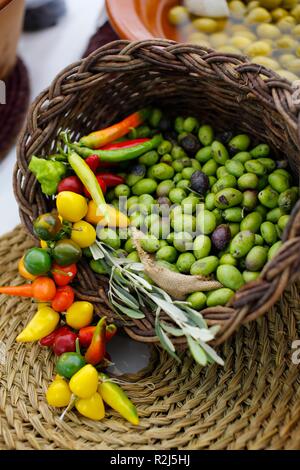 Les olives et les piments à vendre à panier rustique locale dans le marché de la Méditerranée Banque D'Images