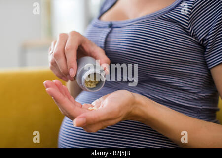 Close Up of pregnant woman Taking comprimés d'acide folique Banque D'Images