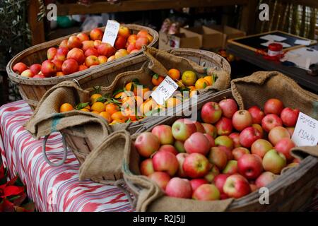 Les pommes et les clémentines à vendre à paniers dans un marché méditerranéen en euros Banque D'Images