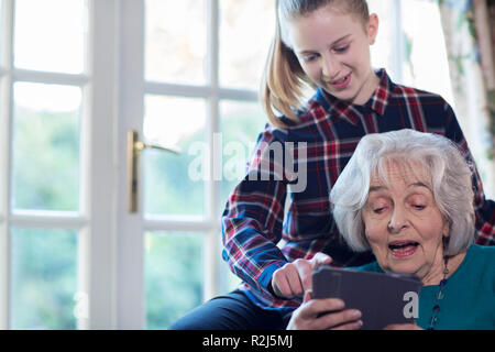 Grand-mère-fille adolescente montrant comment utiliser Digital Tablet Banque D'Images