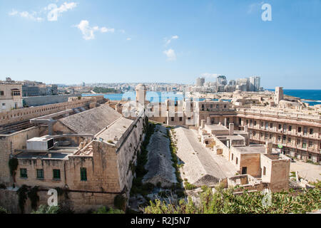 Intérieur du Fort St Elme, La Valette, Malte, en attente de restauration. Le port de Marsamxett et immeubles de grande hauteur de Sliema Point au-delà. Banque D'Images