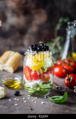 Salade grecque frais de concombre, tomate, poivron, feta et olives , avec de l'huile d'olive dans un bocal en verre Banque D'Images